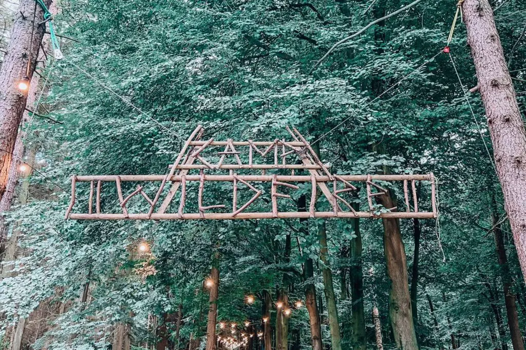 camp wildfire sign hanging from two trees either side