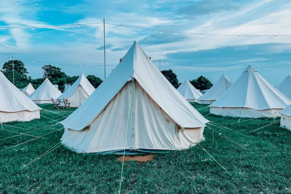 boutique camping. A bell tent is in the centre surrounded by other bell tents.