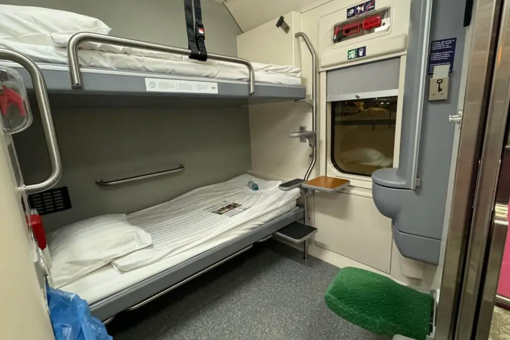 downstairs cabin on the santa claus express night train. You can see a bunk bed for two people and a sink.