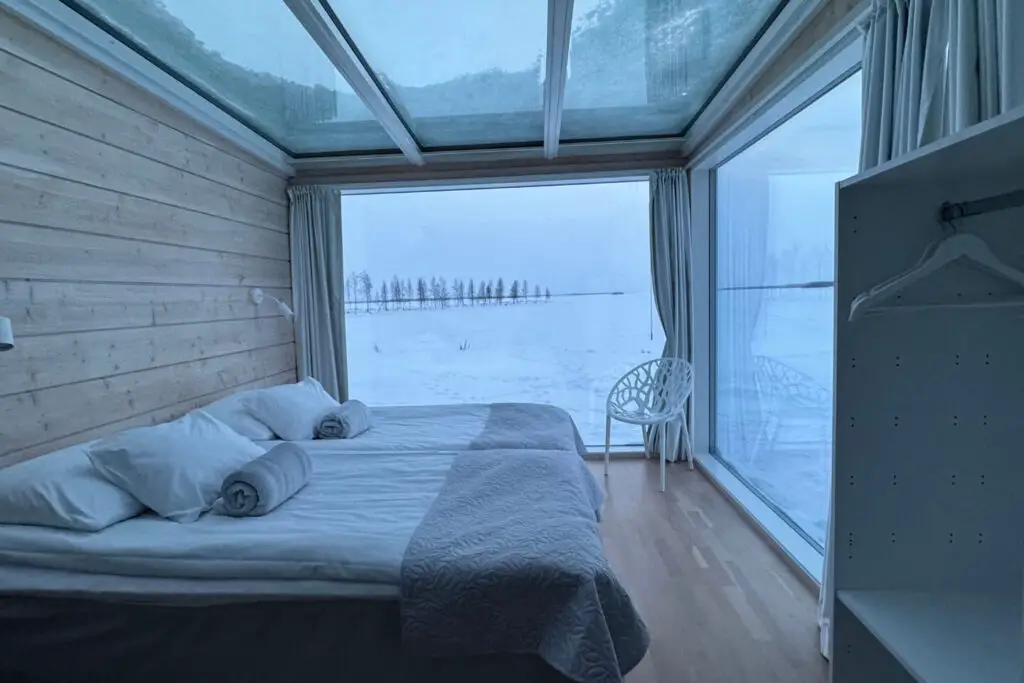 Seaside Glass Villas Kemi interior with two single beds, floor to ceiling windows and a glass roof. things to do in lapland in winter